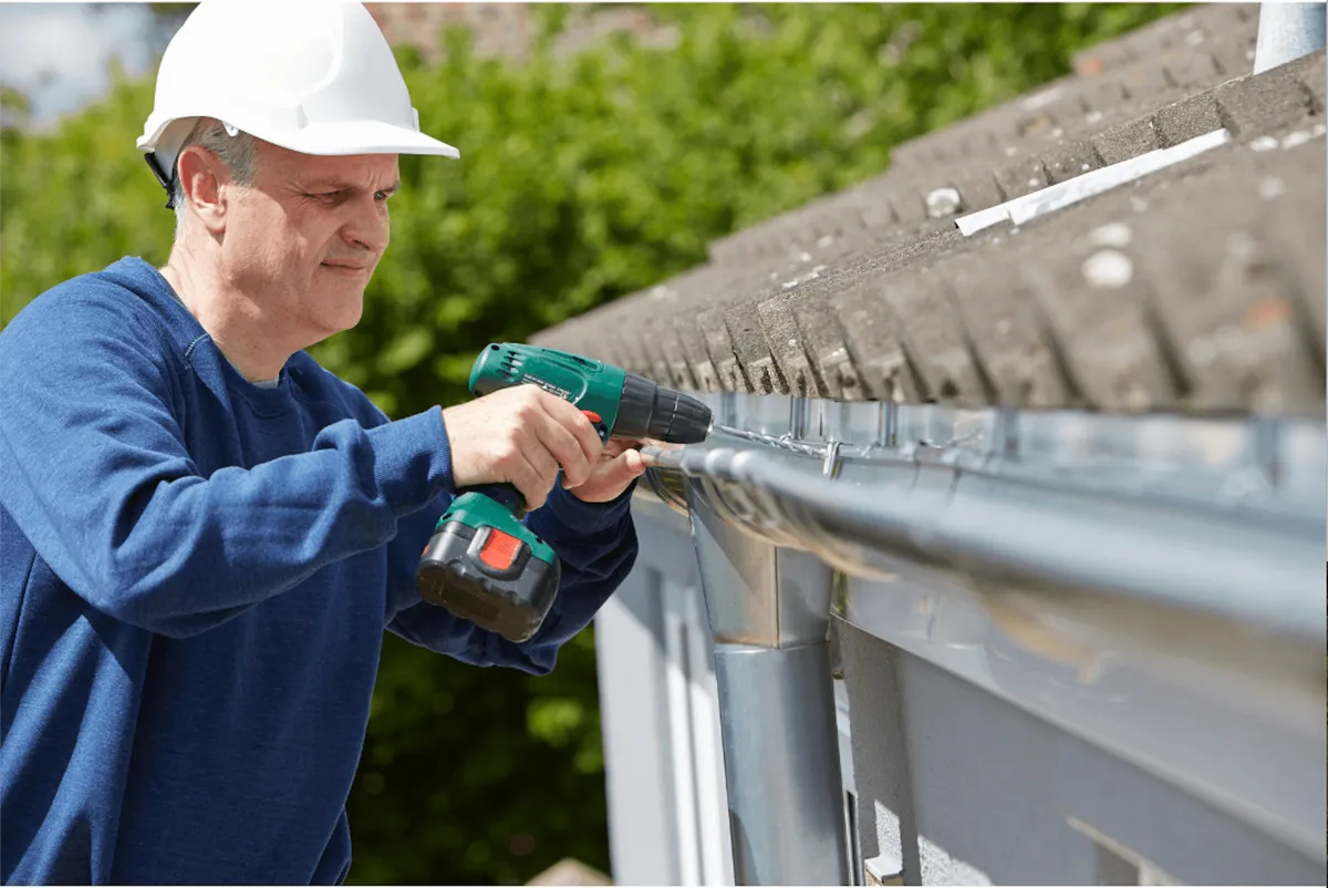 Gutter maintenance on a wooded Westlake Hills lot